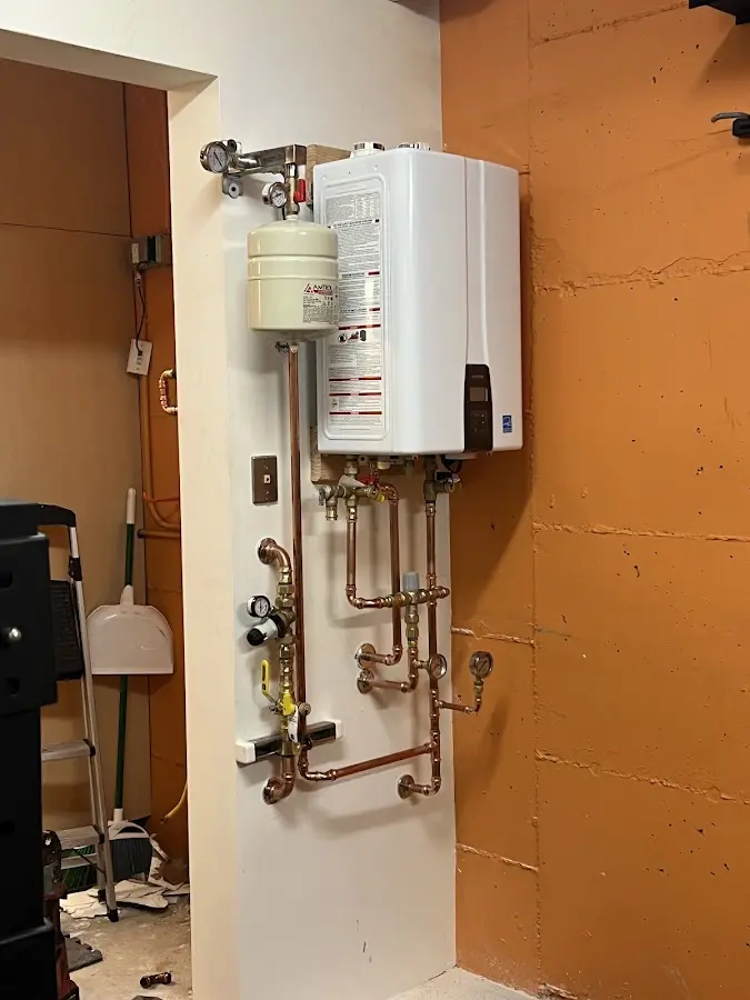 Plumbing technician inspecting water heater connections in Blue Ash